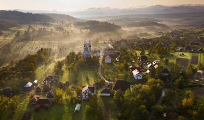 Wall Mural - Aerial view over small rural village of Breb in magic sunrise.