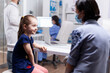 © DC Studio - Mother and daughter at doctor appointment during coronavirus pandemic. Specialist in medicine providing health care services consultation, radiographic treatment in clinic.