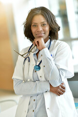 Wall Mural - Smiling woman doctor standing in hospital hallway