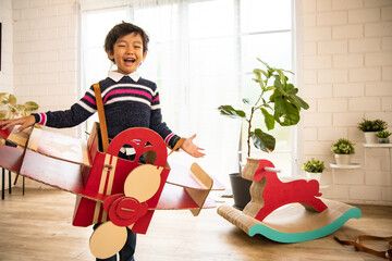 Cute kids playing while parents relaxing at home together, smiling active boy entertaining with paper toy,rocking horse , happy family spending time together in living room on weekend.