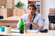 © Elnur - Young male employee drinking alcohol at workplace