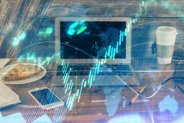 Double exposure of graph and financial info and work space with computer background. Concept of international online trading.