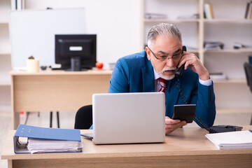 Old male employee working in the office