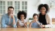 © fizkes - Portrait happy multiracial family drinking pure mineral water in kitchen, smiling African American mother and Caucasian father with two little daughters enjoying fresh aqua, healthy lifestyle concept