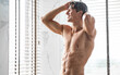 Handsome young male model enjoying taking hot shower