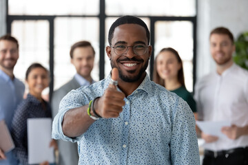 Wall Mural - Best ever. Portrait of loyal excited black male client customer demonstrating thumb up sign recommending good product service, happy african employee looking at camera glad to work in company staff