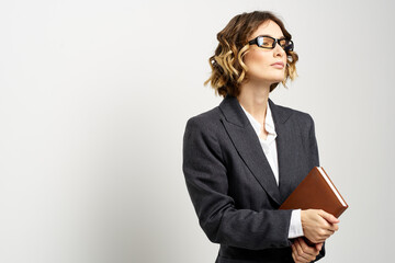 Business woman in a classic suit with a notebook in her hand and glasses on her face Copy Space