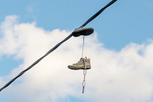 Boots Hanging On Wires Against The Sky