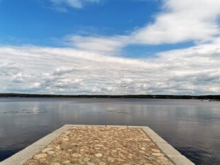 Wall Mural - View of stone pier and sea, cloudy sky