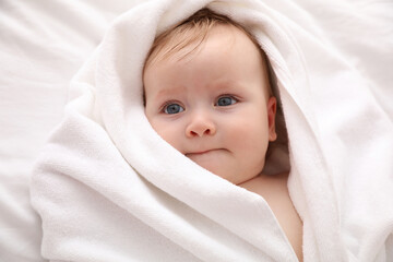 Canvas Print - Cute little baby with soft towel lying on bed after bath, closeup