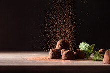 Chocolate Truffles With Mint Leaves On Table Falling Cocoa Powder