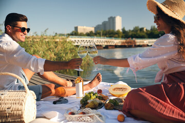 Wall Mural - Couple clinking glasses with wine on pier at picnic