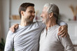 © fizkes - Close up overjoyed mature father with adult son hugging, excited older grandfather and grown up grandchild having fun, chatting, family enjoying leisure time together, two generations bonding