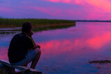 Fototapeta Do akwarium - Teenboy sitting and relaxing on lake beach