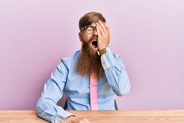 Wall Mural - Young irish redhead man wearing business shirt and tie sitting on the table yawning tired covering half face, eye and mouth with hand. face hurts in pain.