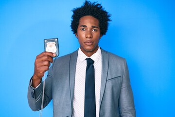 Canvas Print - Handsome african american man with afro hair holding detective badge thinking attitude and sober expression looking self confident