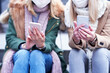Two women using smartphones and wearing masks in the city