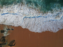 Aerial View Of Sea Waves And Sandy Beach