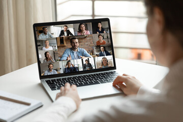 Wall Mural - back rear view focused young female employee involved in video conference brainstorming meeting with