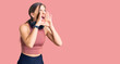 © Krakenimages.com - Beautiful caucasian young woman wearing gym clothes and using headphones shouting angry out loud with hands over mouth