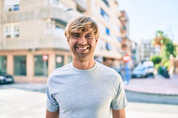 Canvas Print - Young irish man smiling happy walking at street of city.