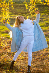 Wall Mural - Beautiful woman in autumn clothes outdoor, blue sky background