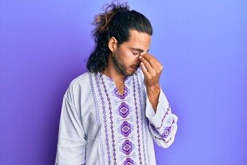 Sticker - Young handsome man with long hair wearing bohemian and hippie shirt tired rubbing nose and eyes feeling fatigue and headache. stress and frustration concept.