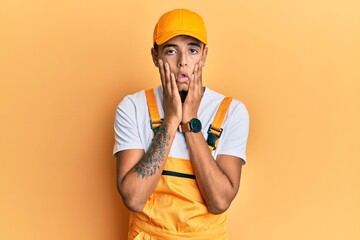 Sticker - Young handsome african american man wearing handyman uniform over yellow background tired hands covering face, depression and sadness, upset and irritated for problem