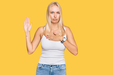 Sticker - Young blonde girl wearing casual style with sleeveless shirt swearing with hand on chest and open palm, making a loyalty promise oath