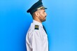 © Krakenimages.com - Handsome man with beard wearing airplane pilot uniform looking to side, relax profile pose with natural face with confident smile.