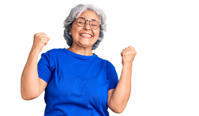 Senior woman with gray hair wearing casual clothes and glasses very happy and excited doing winner gesture with arms raised, smiling and screaming for success. celebration concept.