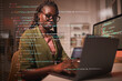 © Seventyfour - Portrait of contemporary African-American woman using laptop with computer code overlay, copy space