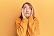 © Krakenimages.com - Beautiful redhead woman wearing casual winter sweater over yellow background tired hands covering face, depression and sadness, upset and irritated for problem
