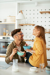 Young couple eating breakfast at home. Loving couple enjoying in the kitchen.