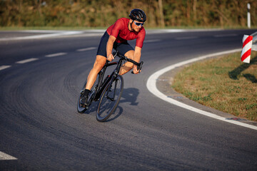 Wall Mural - Sporty man in helmet and glasses riding bike