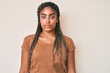 © Krakenimages.com - Young african american woman with braids wearing casual clothes with serious expression on face. simple and natural looking at the camera.