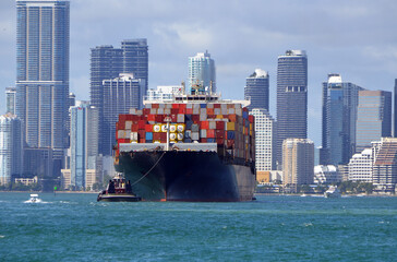 Container ship against a background of Miami's tall building skyline.