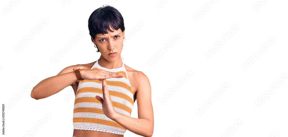 Young brunette woman with short hair wearing casual clothes doing time out gesture with hands, frustrated and serious face