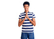 © Krakenimages.com - Young african american man wearing casual clothes praying with hands together asking for forgiveness smiling confident.