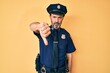 © Krakenimages.com - Middle age hispanic man wearing police uniform looking unhappy and angry showing rejection and negative with thumbs down gesture. bad expression.