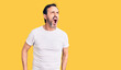 © Krakenimages.com - Middle age handsome man wearing casual t-shirt angry and mad screaming frustrated and furious, shouting with anger. rage and aggressive concept.