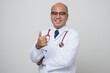 © Chanakon - Doctor in white coat, stethoscope cross his arm and thumb up look into.camera with smile isolated on white background.