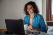 © Stock 4 You - Smiling millennial latin young woman watching movie, app, video call on laptop. Happy hispanic female student has remote online educational class lecture, distant freelance entrepreneur work at home