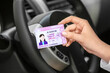 Woman with driving license in car salon