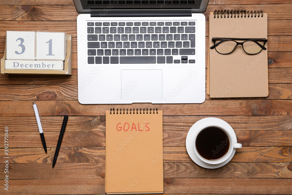 Empty to do list with laptop and calendar on wooden background