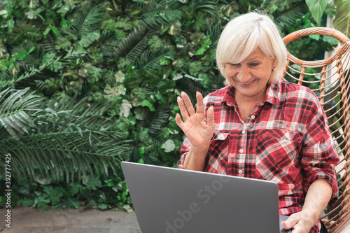 Fotografía Surprised happy elderly woman waves to her companion in video chat