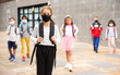 © JackF - Confident teen girl in protective mask walking outside school building on spring day, going to lessons. Concept of necessary precautions in COVID pandemic.