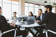 © xartproduction - Group of young business people working and communicating while sitting at the office desk together with colleagues sitting. business meeting