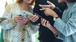 Group of young people using and looking at mobile phone together