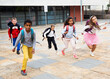 © JackF - Multiethnic group of cheerful tweenagers running together in school yard after lessons in warm autumn day.